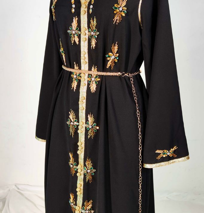 عباية طويلة مخيطة يدوياً بحافة ذهبية ورقبة على شكل حرف V مزينة بحجر الراين